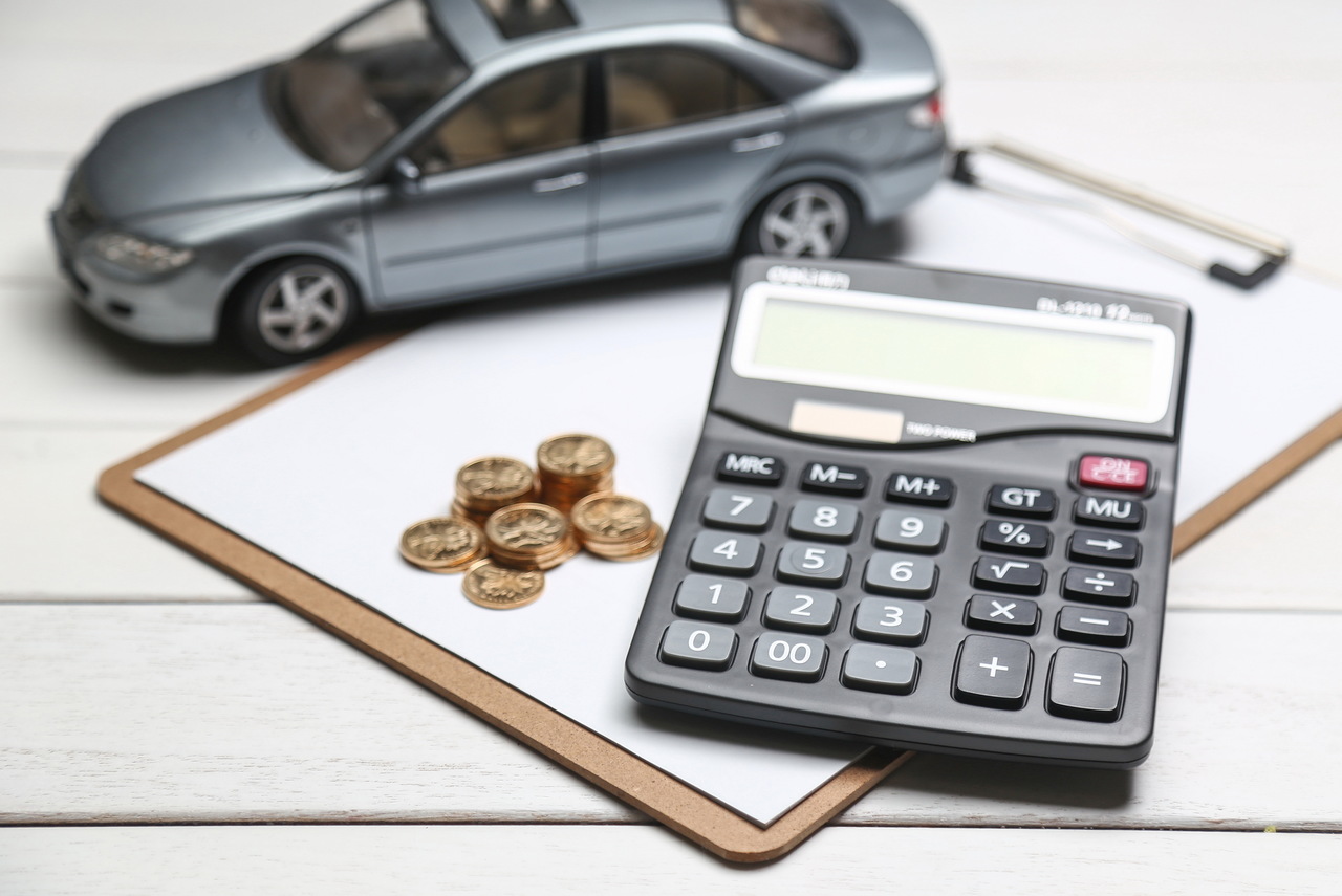 A car model, coins, and a calculator all on top of a loan application