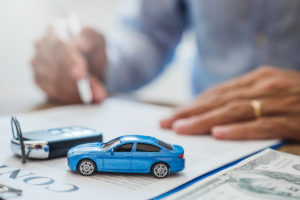 A man signing a contract for a car loan