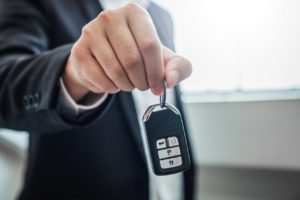 A sales agent present a key to a secondhand car