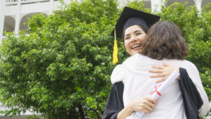 A newly graduated college student hugging her mother