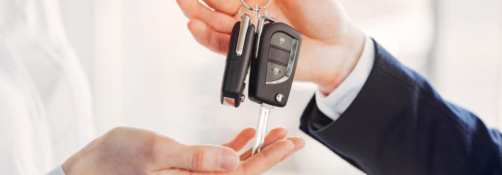 A man handing out car keys to another person