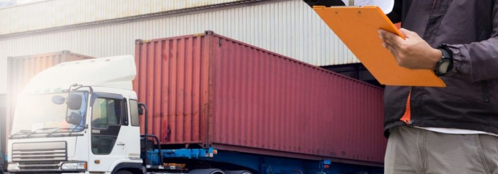 A man holding a clipboard in front of a truck