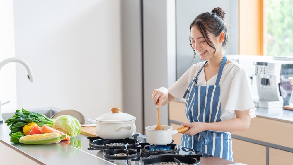 Asian woman cooking vegetables in a kitchen