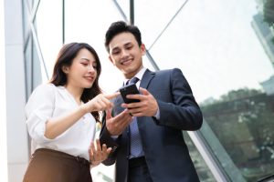 Two people looking and using a smartphone