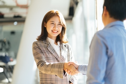 Young Asian woman shaking hands with a man